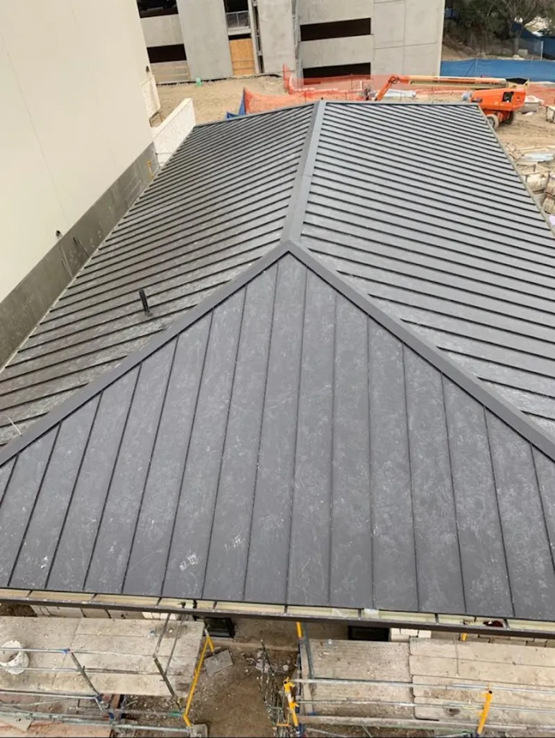 Commercial metal roof construction with crane equipment in Charlton